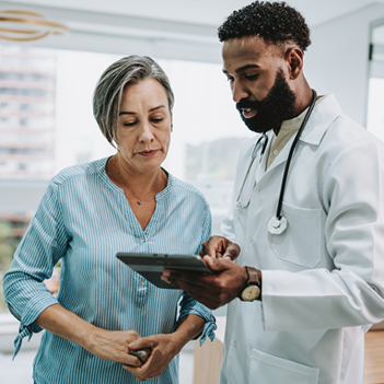 Two healthcare professionals review the summary table